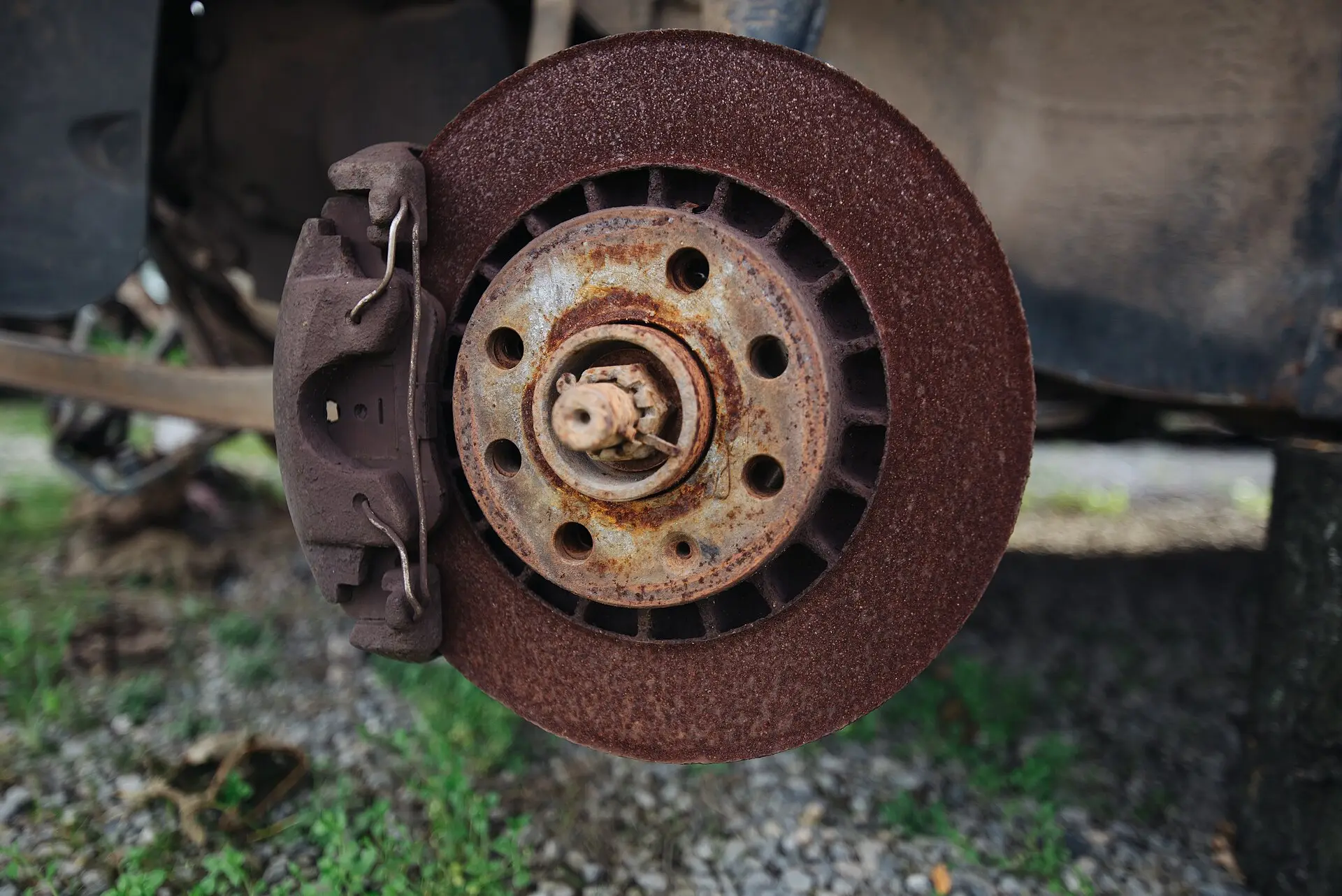 A worn, rusted brake disc and caliper