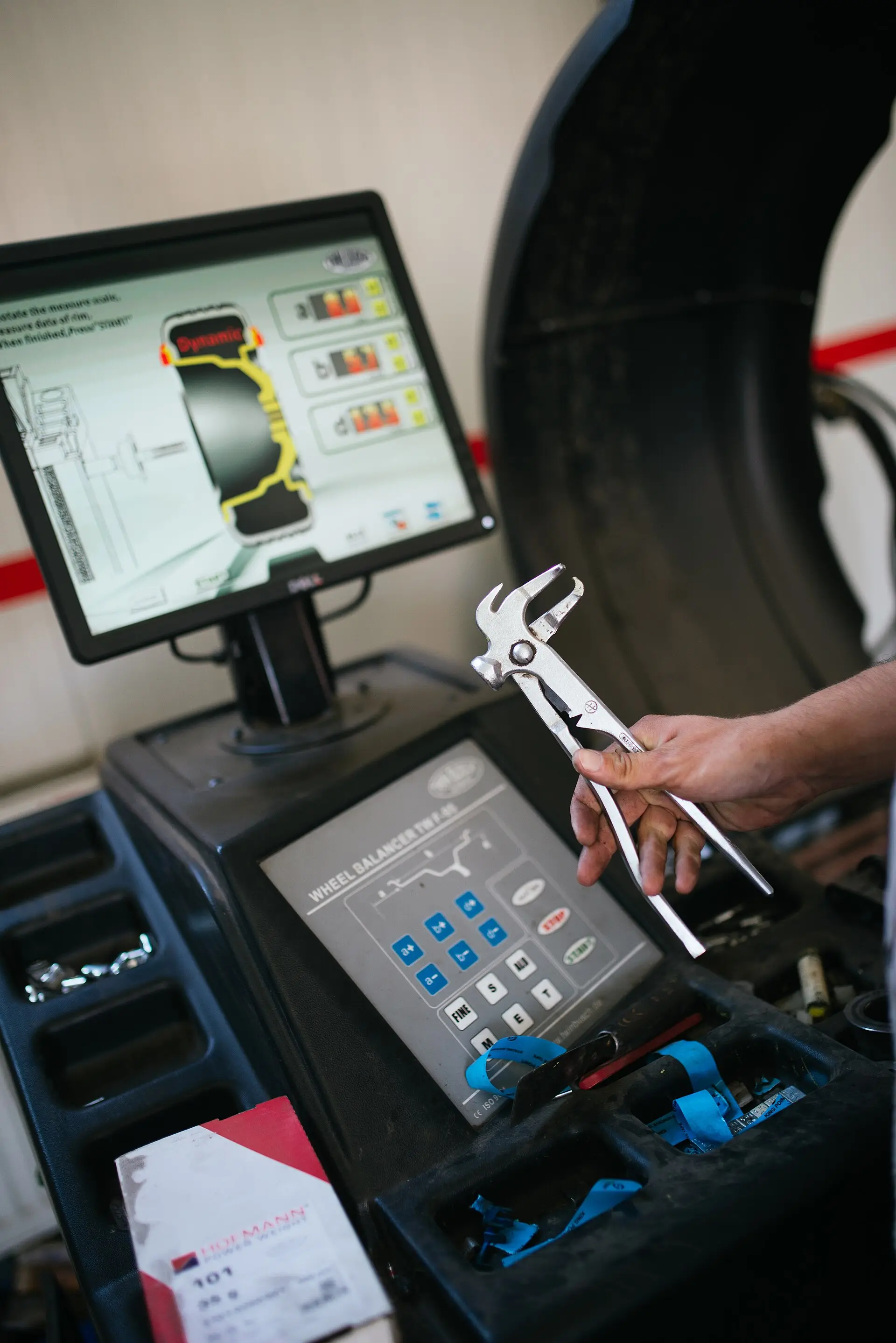 A technician connects a scan tool to a car at a service centre