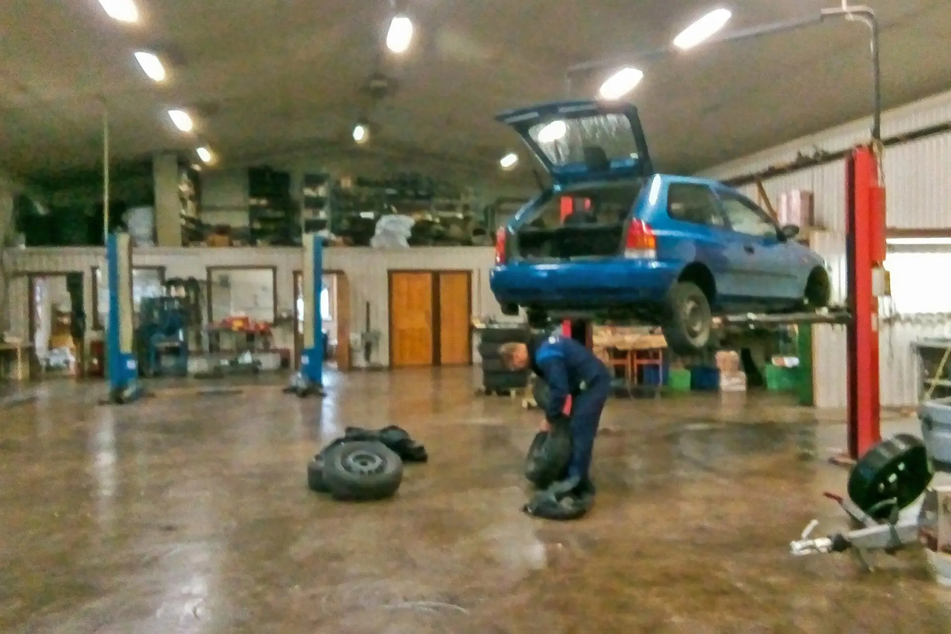 Cars raised on lifts in a bright repair garage